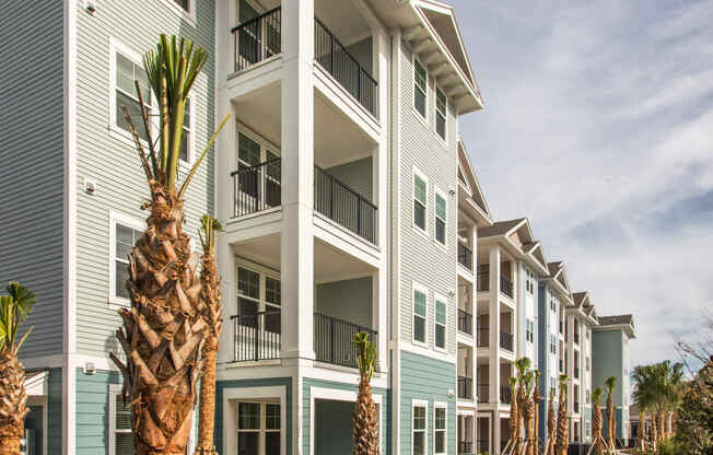 an apartment building with palm trees in front of it