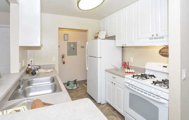 a white kitchen with white appliances and white cabinets