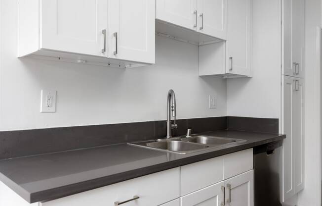 a kitchen with white cabinets and a sink