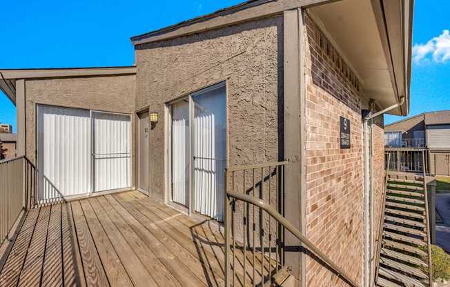 A second-floor apartment building deck at Montfort Crossing Apartments in Dallas, TX.