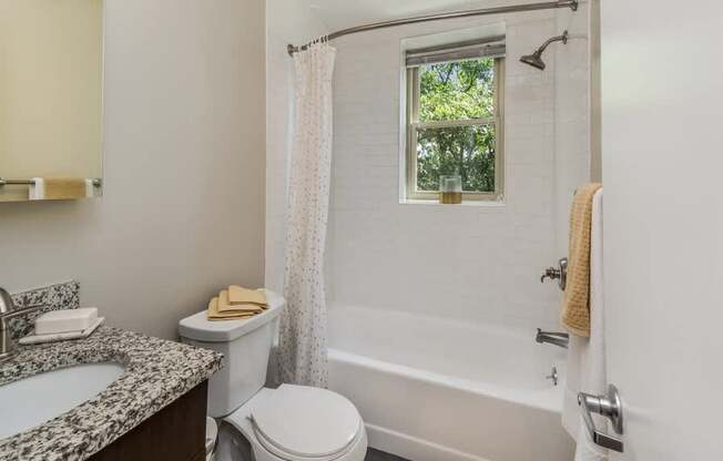 A white bathroom with a toilet, sink, and bathtub.