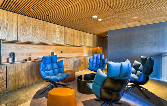 A room with blue chairs and a wooden wall.