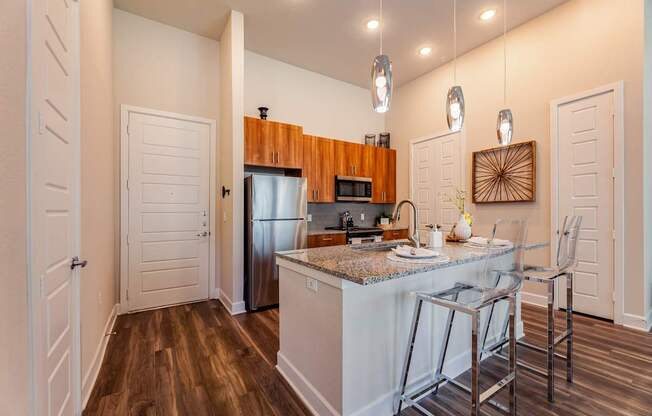 A kitchen with a white island and a refrigerator.
