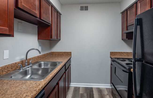 a kitchen with black appliances and brown cabinets