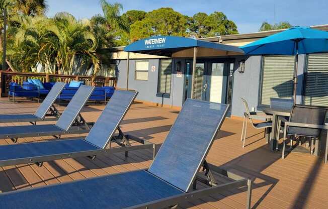 A water slide area with a blue umbrella and chairs.