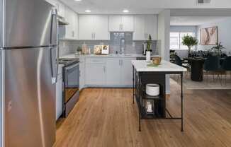 a kitchen with white cabinets and stainless steel appliances
