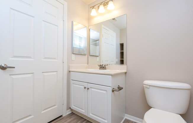 a bathroom with a toilet sink and mirror
