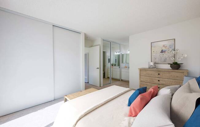 A bedroom with a bed, dresser, and mirror.