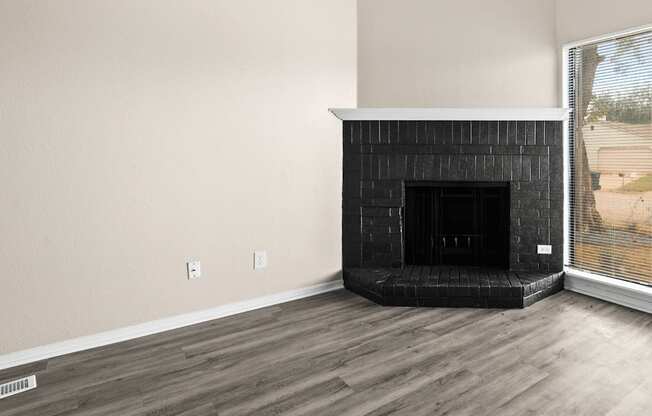 an empty living room with a fireplace and a window at Diamond Ridge Townhomes, Oklahoma City, OK 73114