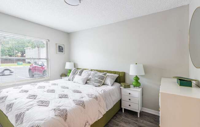 A bedroom with a bed, nightstand, and lamp.