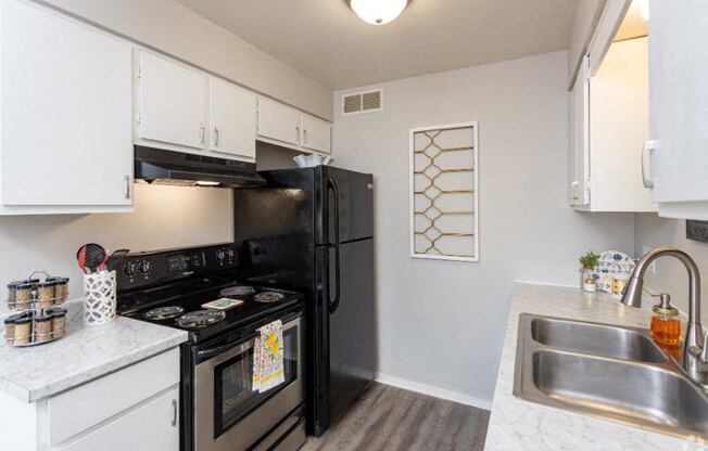 a kitchen with a stove refrigerator and sink
