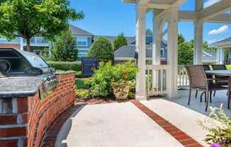 A house with a white porch and a brick wall.