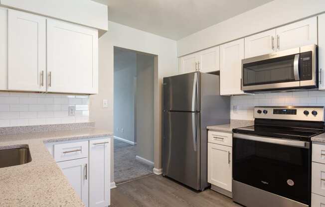 a kitchen with white cabinets and stainless steel appliances