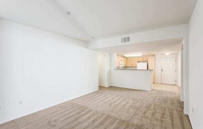 A large empty room with a carpeted floor and white walls. at La Jolla Crossroads Apartments, California