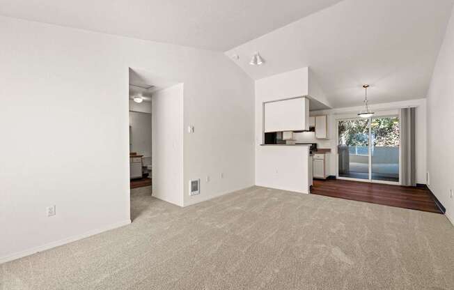 A large, empty room with a carpeted floor and a doorway leading to another room at Clackamas Trails Apartments, Oregon, 97222