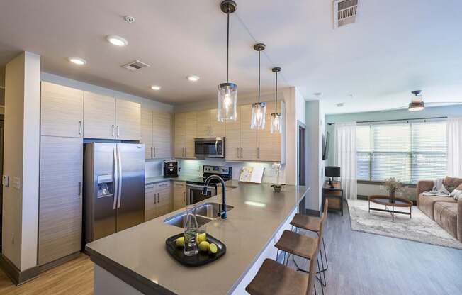 A modern kitchen with a large island and stainless steel appliances.