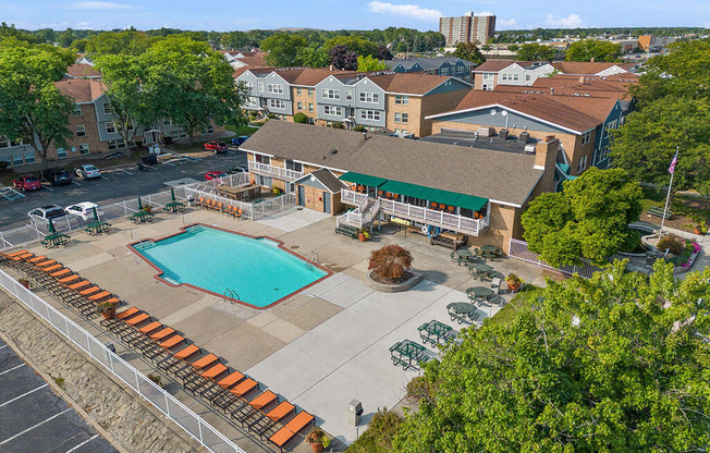 A pool surrounded by bleachers in a residential area.