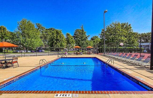 a large pool with chairs and umbrellas around it