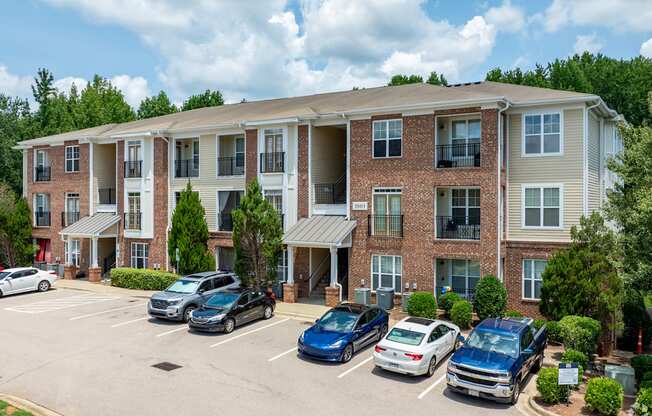 A parking lot in front of a multi-story apartment building.