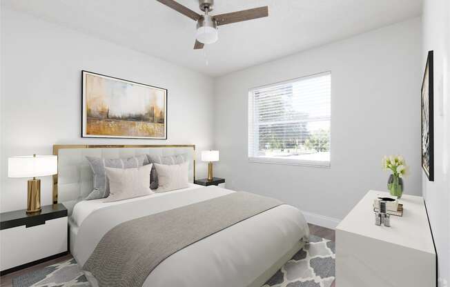 a white bedroom with a large bed and a ceiling fan