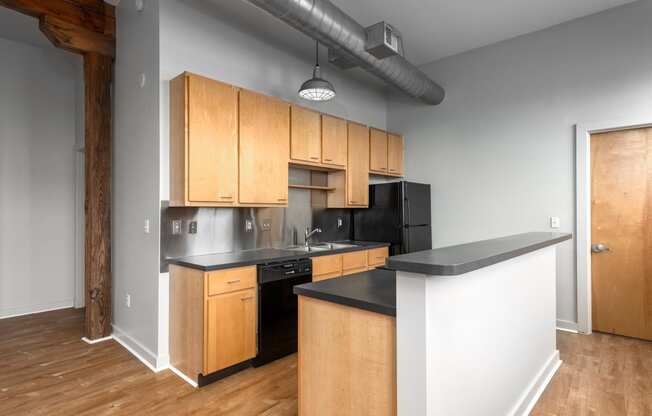 an empty kitchen with wooden cabinets and black counter tops