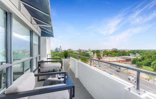 A balcony with a table and chairs overlooking a busy street.at Iris Luxury Apartments, Memphis, TN 38105