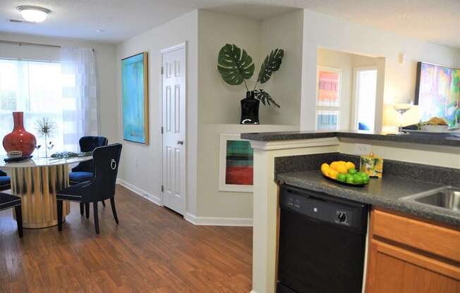 A kitchen with a black dishwasher and a black chair.