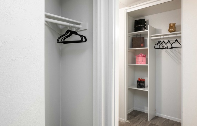 a walk in closet with shelves and a hanger on the wall