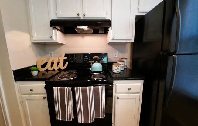 a small kitchen with black appliances and white cabinets