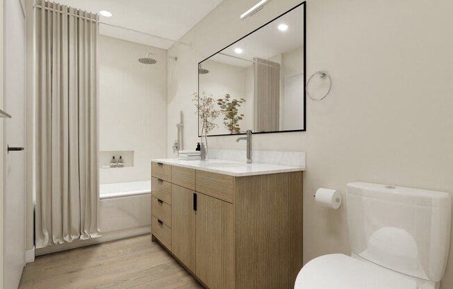 A modern bathroom with a wooden vanity and a white toilet.