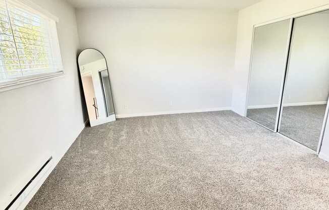 Campbell Plaza Apartments
710 Nido Drive, Campbell, CA 95008 A room with a carpeted floor and a mirror on the wall.