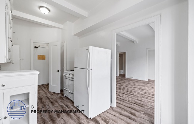 a renovated kitchen with white cabinets and a white refrigerator