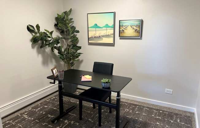 a work from home space with a plant and pictures on the wall