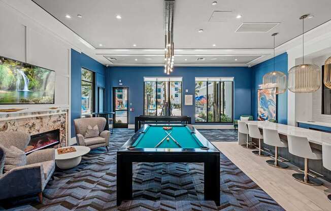 A room with a pool table and a fireplace.