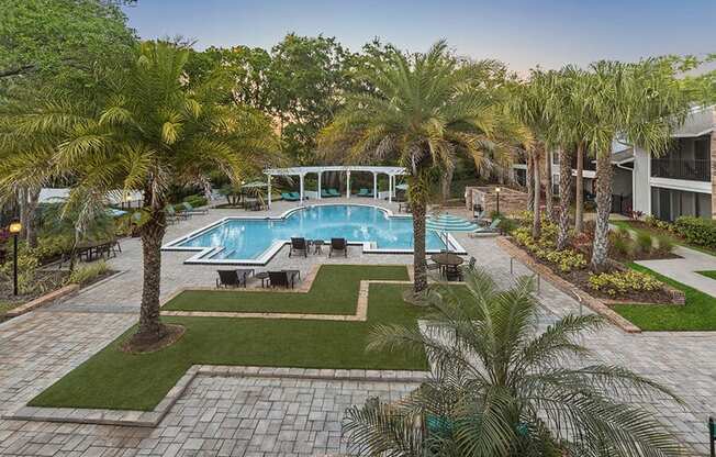 Aerial View of Community Swimming Pool with Pool Furniture at Grand Pavilion Apartments in Tampa, FL.