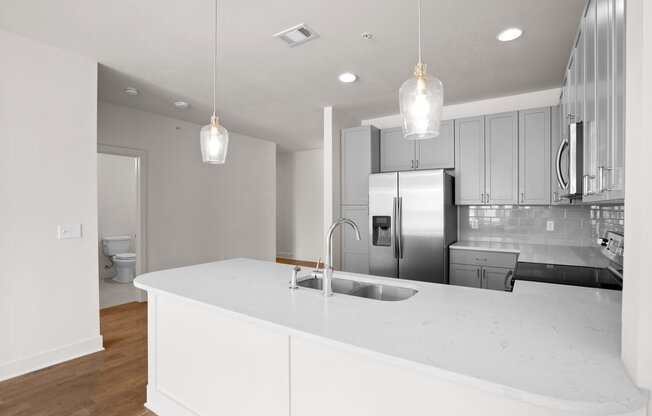 a kitchen with a white counter top and a stainless steel refrigerator