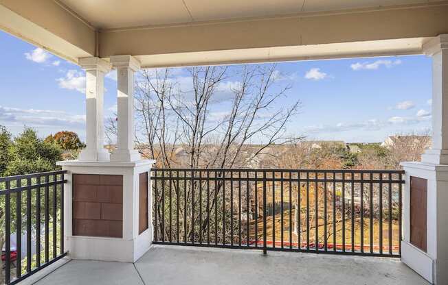 the view from the front porch of a home with a balcony and a fence