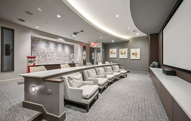 A modern home theater with a curved screen and comfortable seating.