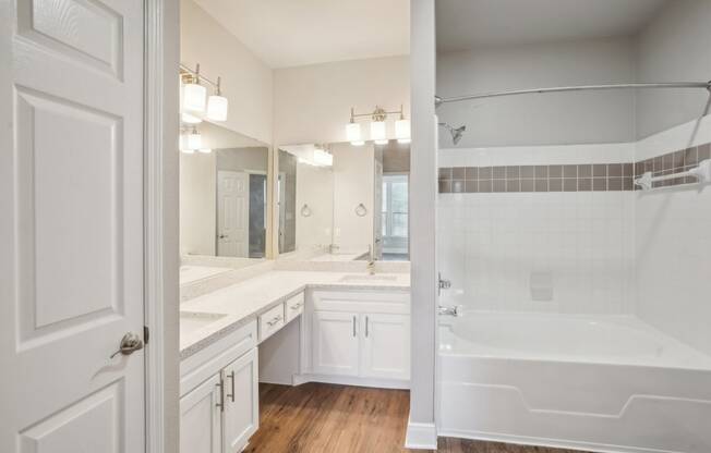 a bathroom with a tub and a sink and a mirror  at The Verandah, Austin, TX, 78726