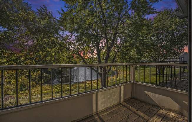 a balcony with a view of a pond and trees at Hampton Lakes Apartments, Michigan, 49534