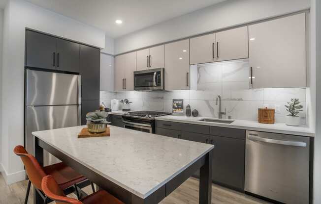 a kitchen with stainless steel appliances and a marble counter top