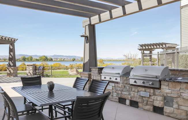 a patio with a table and chairs and a grill