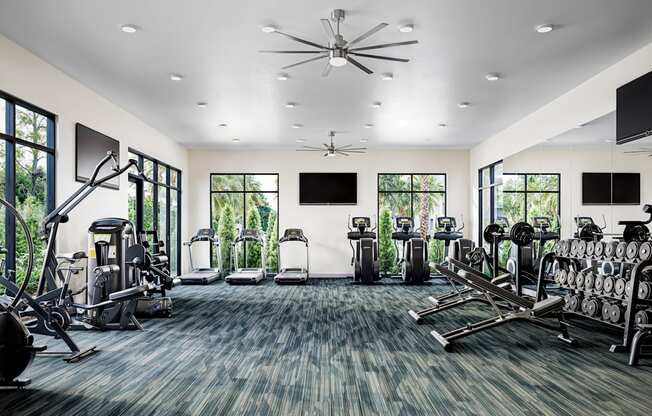 a gym with cardio machines and televisions