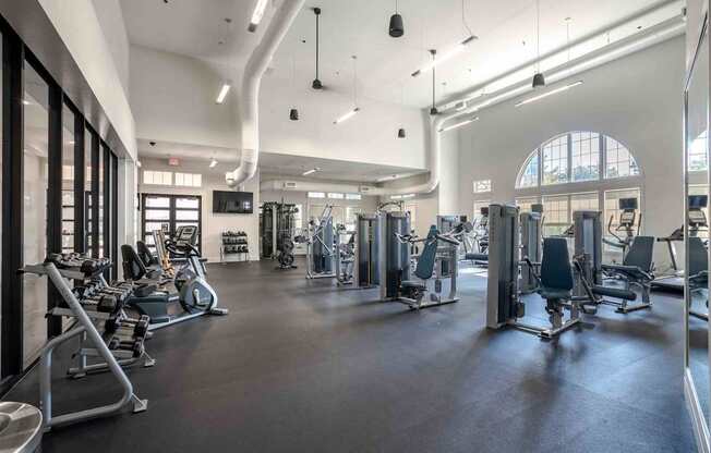 A spacious gym with a variety of equipment and a large window.