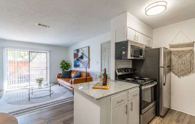 A kitchen with a refrigerator, oven, and microwave.