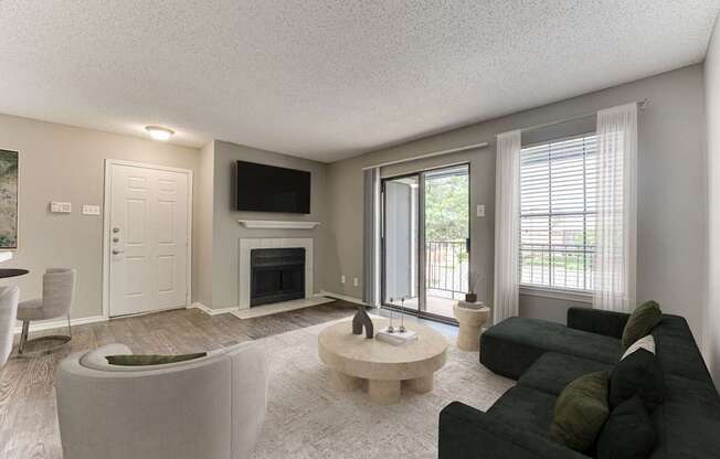 A living room with a black couch and a fireplace.