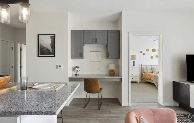 a kitchen with a breakfast bar and a bedroom in the background
