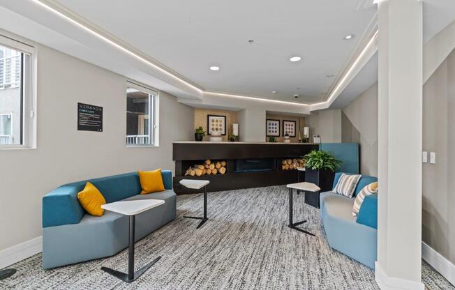 a lobby with blue couches and yellow and blue pillows