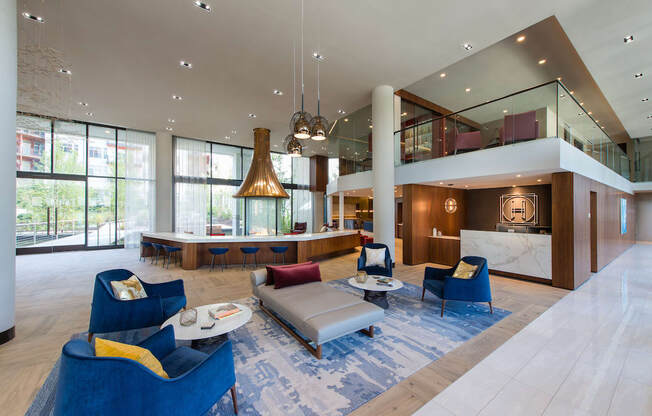 the lobby of a hotel with blue chairs and couches