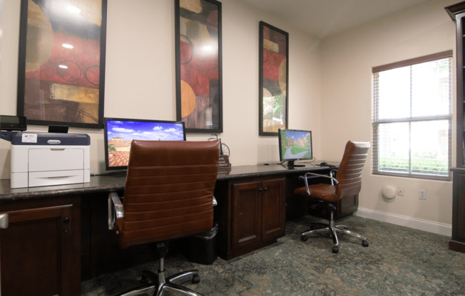 A room with two chairs and two computers.